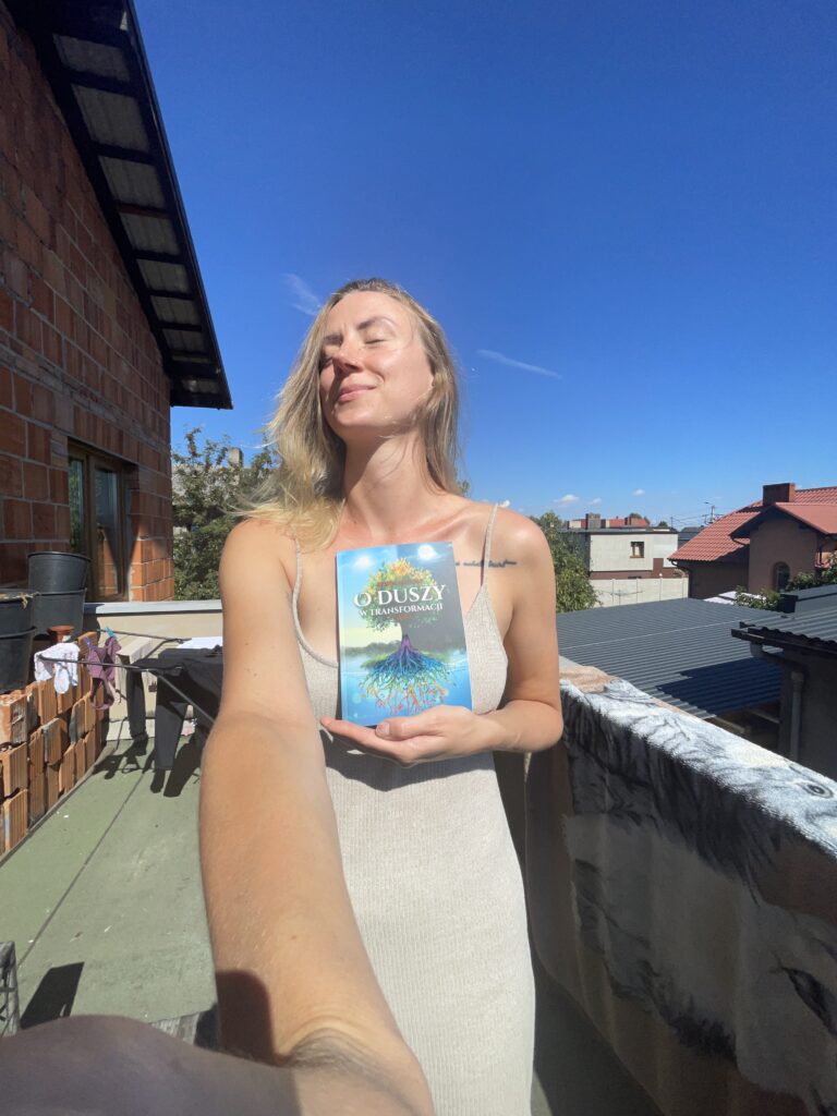 Sylwia trzyma swoją pierwszą publikację O duszy w transformacji. Część 1.